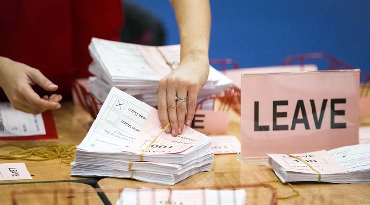 A teller counts ballot papers at the Titanic Exhibition Centre in Belfast, Northern Ireland, after polls closed in the EU referendum Thursday, June 23, 2016. Britain's referendum on whether to leave the European Union was too close to call early Friday, with increasingly mixed signals challenging earlier indications that "remain" had won a narrow victory. (Liam McBurney/PA via AP) UNITED KINGDOM OUT NO SALES NO ARCHIVE